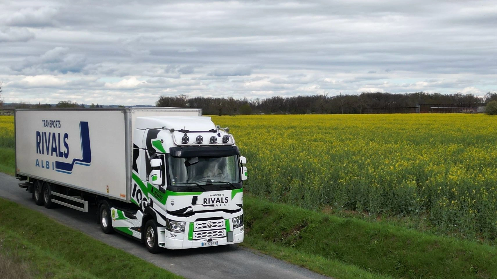 Camion des Transports Rivals dans un champs de colza, roulant à l'oléo 100